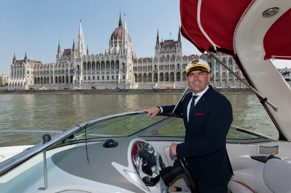 Lajkó Ferenc, a Riverlux kapitánya a hajó kormányánál, háttérben a Parlament